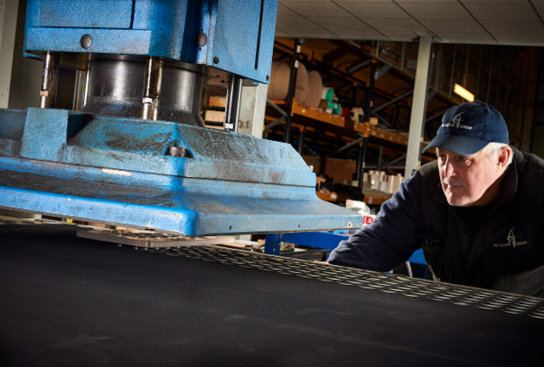 Press cutting gaskets. A press cutting gaskets from a black rubber material.