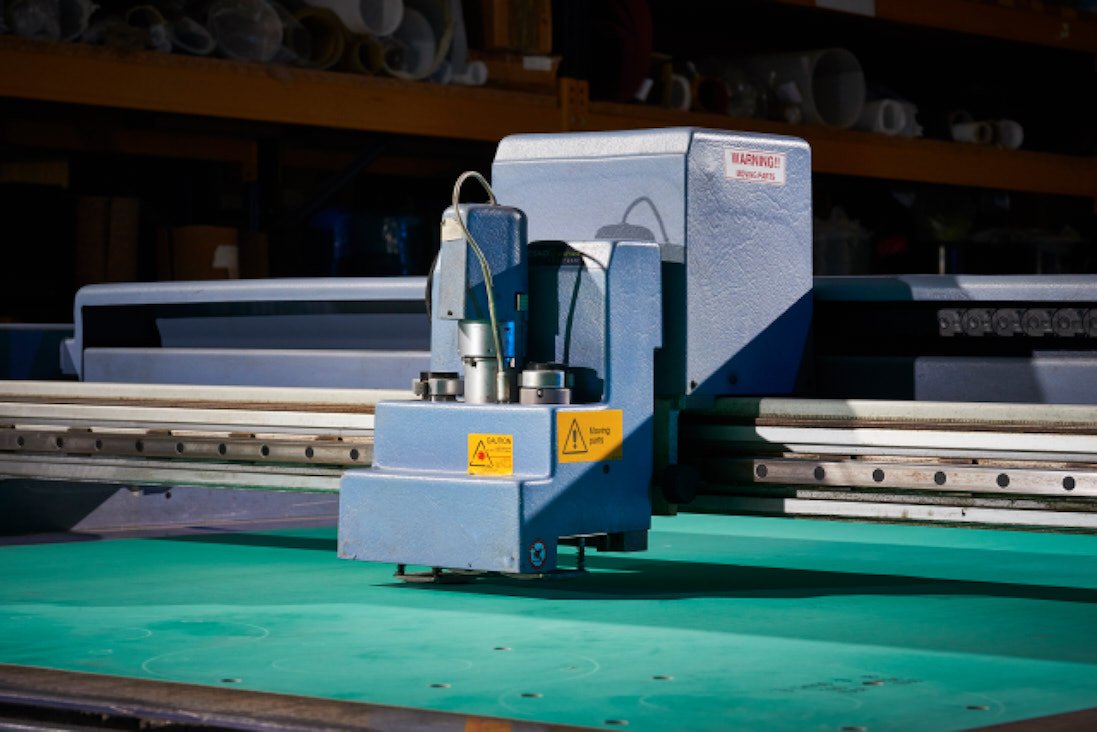 Green compressed fibre sheet material being cut into gaskets